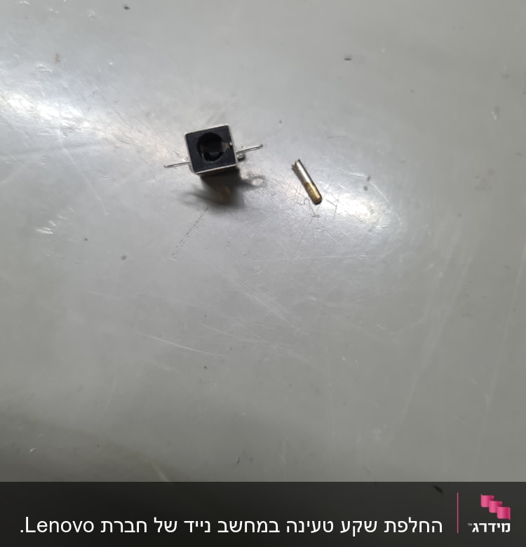 רכיב אלקטרוני קטן עם פינים על משטח אפור